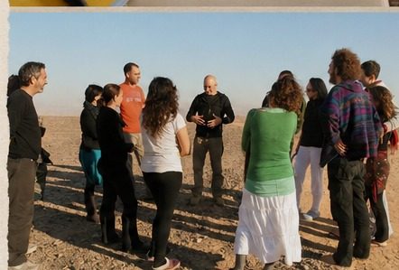 A group standing in a circle in the desert